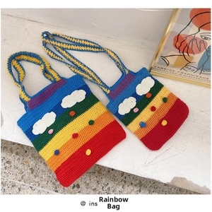 Detail of colorful handmade crochet rainbow bags with wool clouds and decorative poms