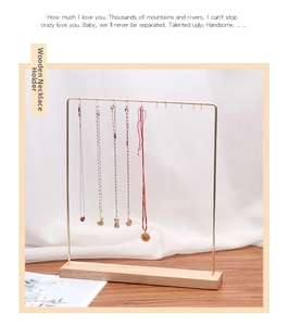 Detail of gold metal necklace stand with ten hooks and a minimalist wooden base