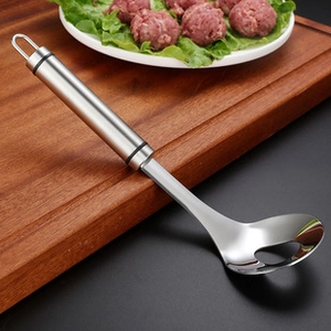 Detail of stainless steel meatball spoon with a round hole and black non-slip handle