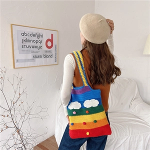 Rainbow knit crochet tote bag with cloud accents shown being worn over the shoulder
