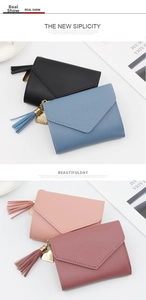 Close-up of small tri-fold wallets with lychee texture, heart charms and tassel details