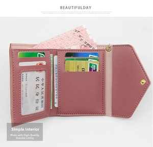 Detail view of pink tri-fold women's wallet interior with card slots and clear ID window