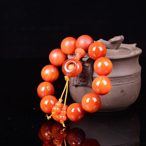 Detail of 20mm amber wood beads with oil gloss and gourd charm on a teapot