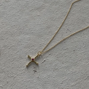 Detailed macro shot of vintage 925 silver cross necklace with a red gemstone centerpiece