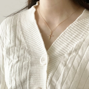 Close-up of 925 sterling silver gold cross necklace with red gemstone on neck
