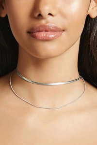 Close-up of double-layer silver herringbone and round snake chain choker on neck