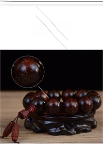 Dettaglio ravvicinato di grani in legno di sandalo rosso con fini trame dorate a stella