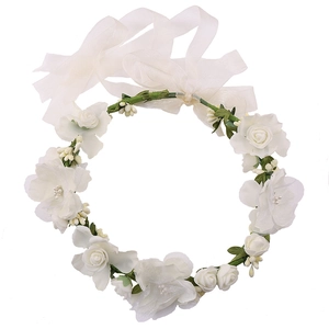 Detail of white artificial rose bridal garland with green leaves and ribbon