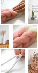 Detail of pink and beige woven back scrubber showing fine mesh texture and cotton rope