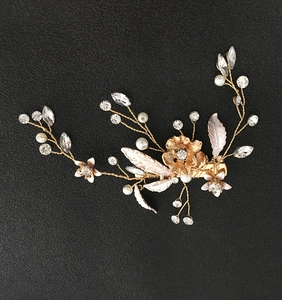 Détail de la pince à cheveux mariée avec feuilles dorées, perles et strass brillants