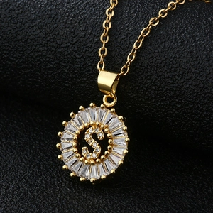 Gros plan du pendentif médaille lettre S avec zircons cubiques en or et coupe baguette