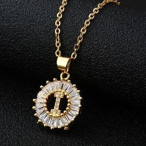 Vue macro du pendentif lettre I dorée avec oxydes de zirconium sur fond en cuir noir