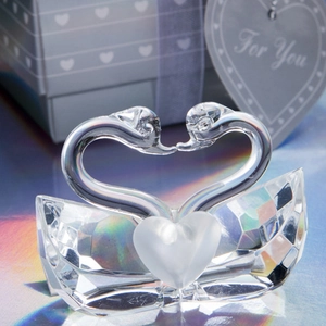 Macro shot of two crystal swans forming a heart shape on a faceted base gift