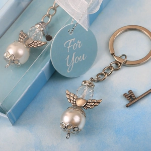 Detail of angel wing keychain with pearl in a light blue gift box and For You tag