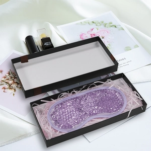 Detail of purple gel bead eye mask presented in a black gift box on white satin silk