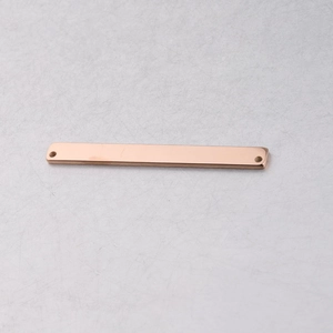 Detail of rose gold rectangular connector with rounded corners and double holes