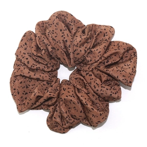 Oversized leopard print scrunchie made of soft brown fabric with black spotted pattern