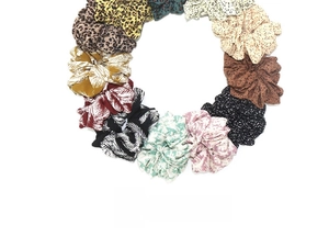 Flat lay detail of 12-piece scrunchie set featuring leopard print and floral patterns
