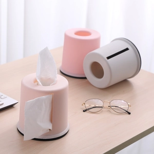 Detail view of modern round pink and grey tissue dispensers on a minimalist desk surface