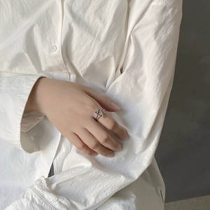 Detail of minimalist 925 silver star ring featuring a woven double band design