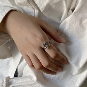 Close-up of vintage 925 sterling silver star ring on hand with woven texture details