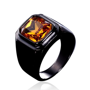 Détail d'une bague chevalière noire pour homme avec une grande pierre ambre facettée