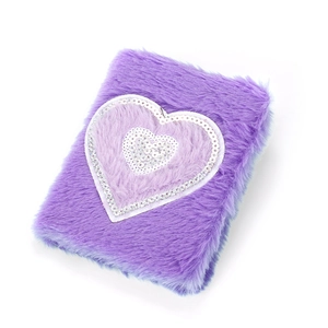 Detail of purple plush unicorn notebook cover featuring a sparkly sequin heart pattern