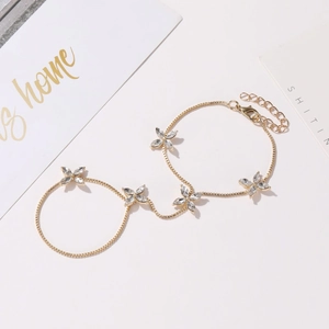 Bracelet bague doré élégant orné de cinq papillons en zircone sur fond blanc épuré