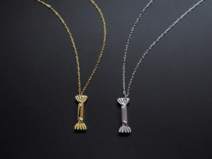 Close-up of titanium steel candy pendants in gold and silver finish with detailed metal texture