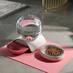 Pink pet gravity water dispenser set with food bowl and silicone mat on tile floor