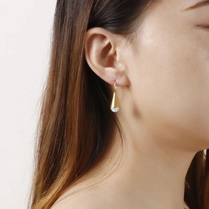 Minimalist gold teardrop earrings for women with white crystal accents on a model