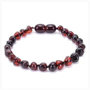 Dettaglio di perline irregolari in ambra baltica rosso scuro per bracciale da neonato