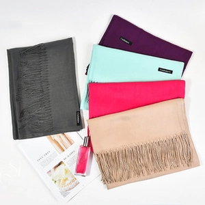 Detail showing various colors of thick cashmere-feel scarves with soft fringe tassels
