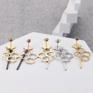 Titanium steel geometric earrings set in gold and silver on hexagonal display