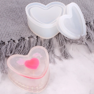 Macro shot of heart-shaped silicone resin mold with finished storage box on marble surface