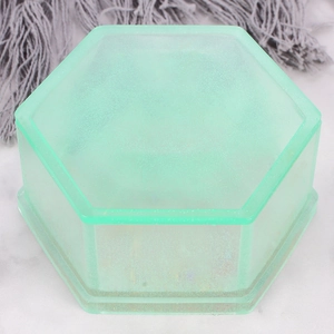Detail of a light green translucent hexagonal resin storage box with subtle glitter finish