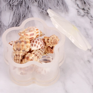 Macro shot of flower-shaped silicone jewelry box mold with lid on marble surface