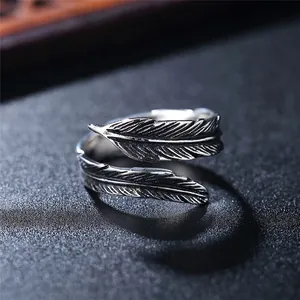 Vintage oxidized silver feather ring with detailed textures and adjustable open band