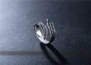 Macro view of vintage silver feather ring showing detailed metallic textures and textures