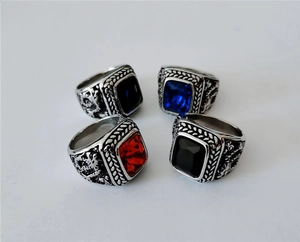 Detailed view of men's vintage dragon rings with red, blue, and black gemstones