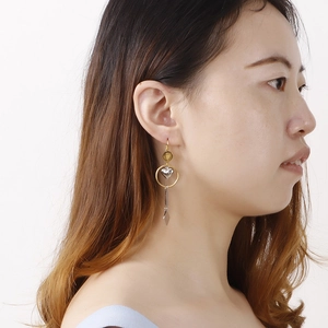 Fashion geometric long drop earrings with gold ring and silver heart on a female model