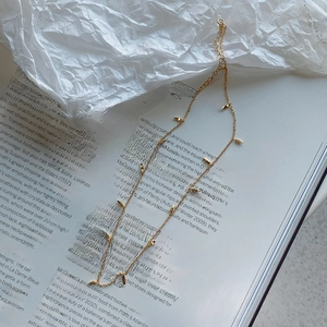 Detailed view of 925 sterling silver gold leaf pendant necklace on aesthetic magazine