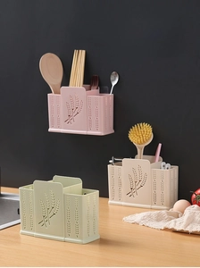 Close-up of the hollowed drainage holes on a three-compartment wall-mounted utensil holder