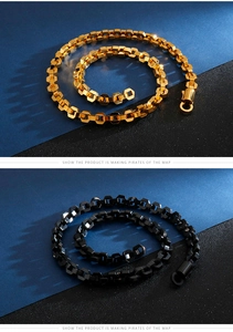 Detail of hexagonal honeycomb chain links in gold and matte black finish with round clasp