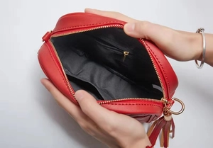 Macro dell'interno della borsa in pelle rossa con fodera nera e dettagli dorati