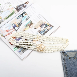 Detail of four-row pearl elastic belt with a rhinestone flower buckle on a fashion magazine