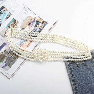Detail of four-row pearl elastic belt with a sparkling rhinestone flower buckle decoration
