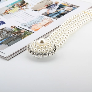 Close-up of elegant four-row pearl elastic belt with sparkling rhinestone buckle