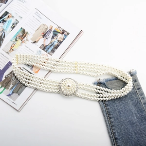 Detailed view of triple-layer pearl waist belt with luxury crystal flower buckle