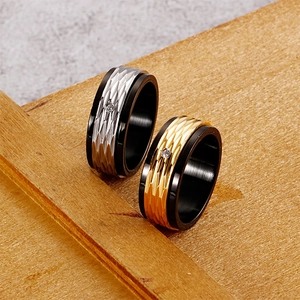 Anelli bicolore in acciaio inossidabile nero e oro rosa con zircone su fondo legno